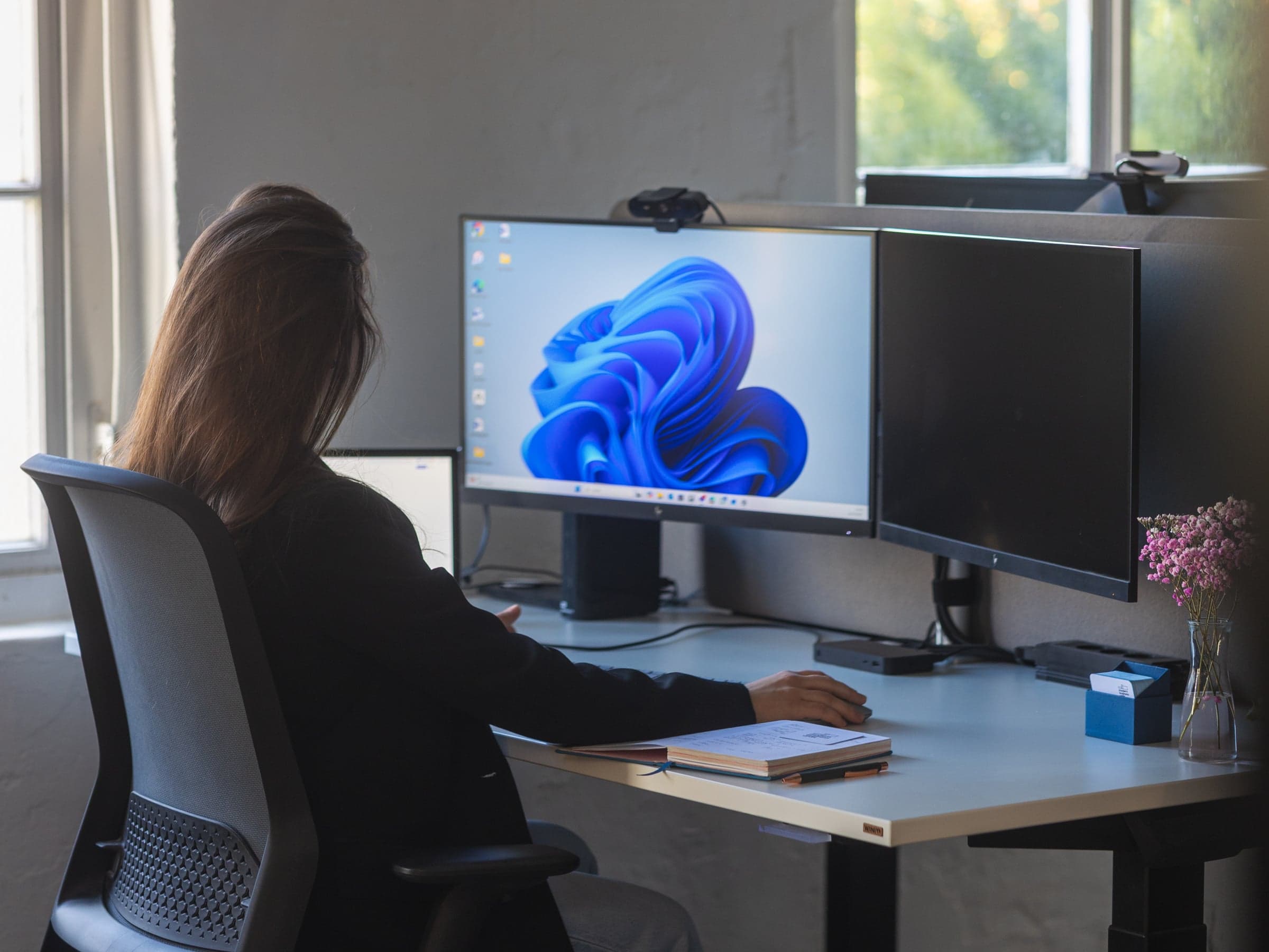 Person at a workstation with two monitors