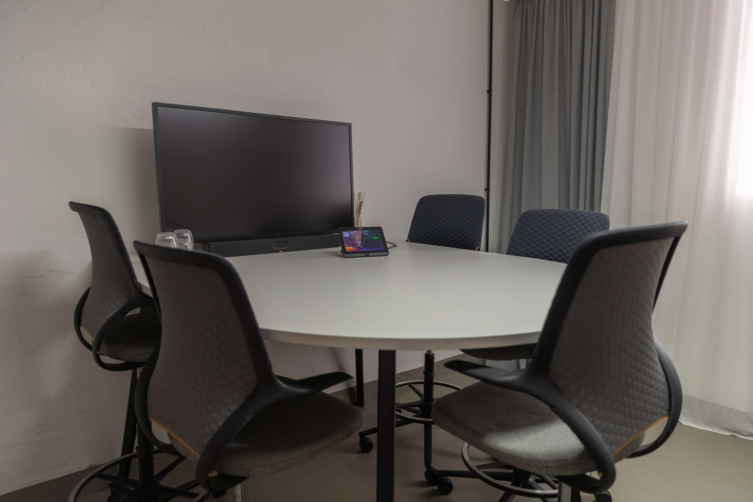 Meeting room with a round high table and screen